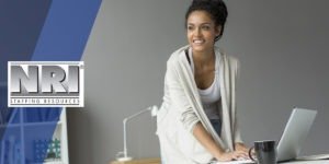 A smiling female accountant at a desk with a laptop