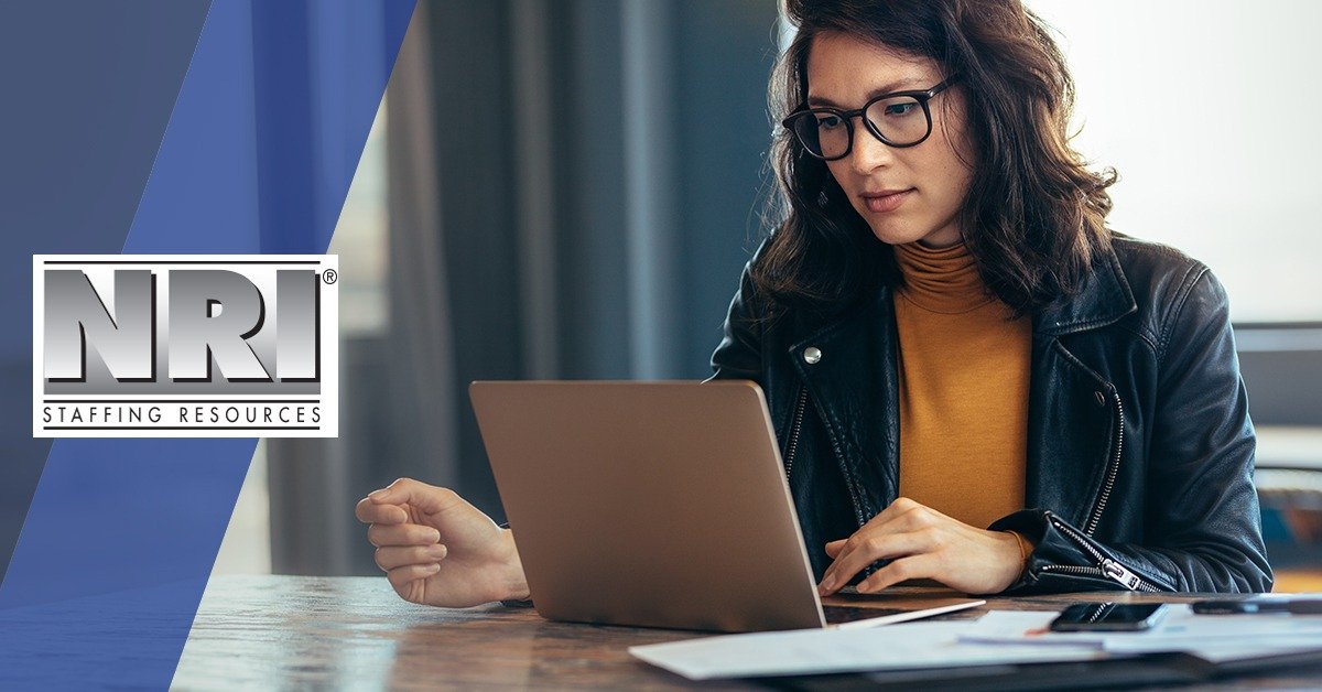 woman with glasses looking at a laptop