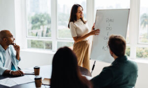 A female speaking to her team about employee retention strategy in 2026.