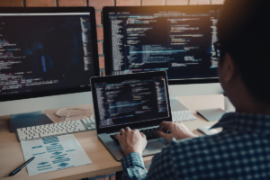 IT professional working on multiple monitors, highlighting skills and experience that align with the best paying IT certifications and high-demand tech careers.