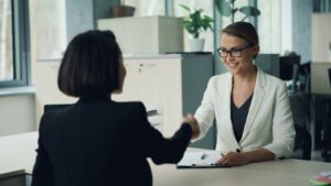 Candidate shaking hands with hiring manager during a second interview, representing what to expect at the second interview in the hiring process.