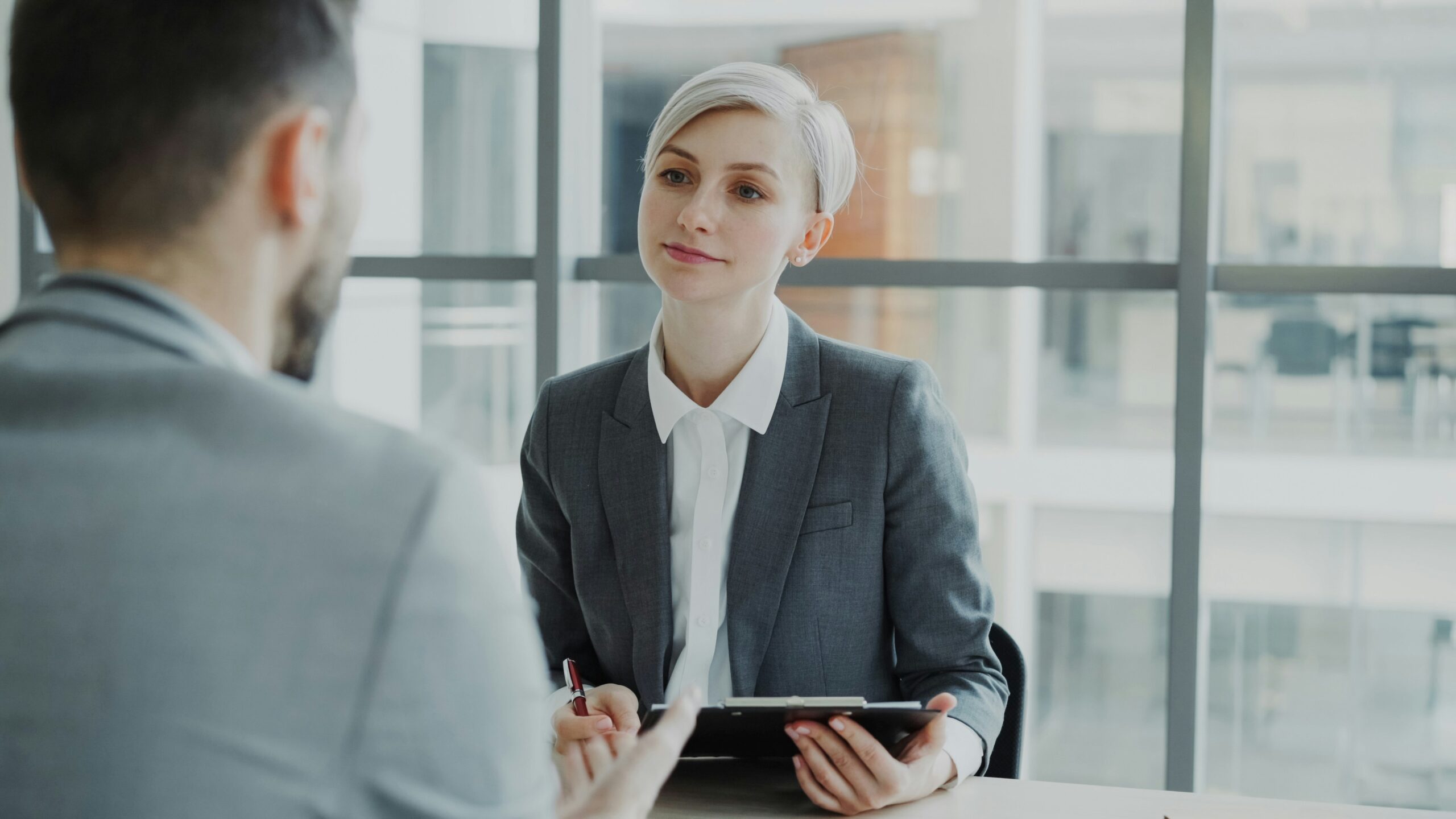 how to find a job through a staffing agency — recruiter interviewing a candidate at an office desk