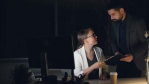 legal staffing agency — attorney and paralegal reviewing urgent caseload documents together during a late night surge at a law firm