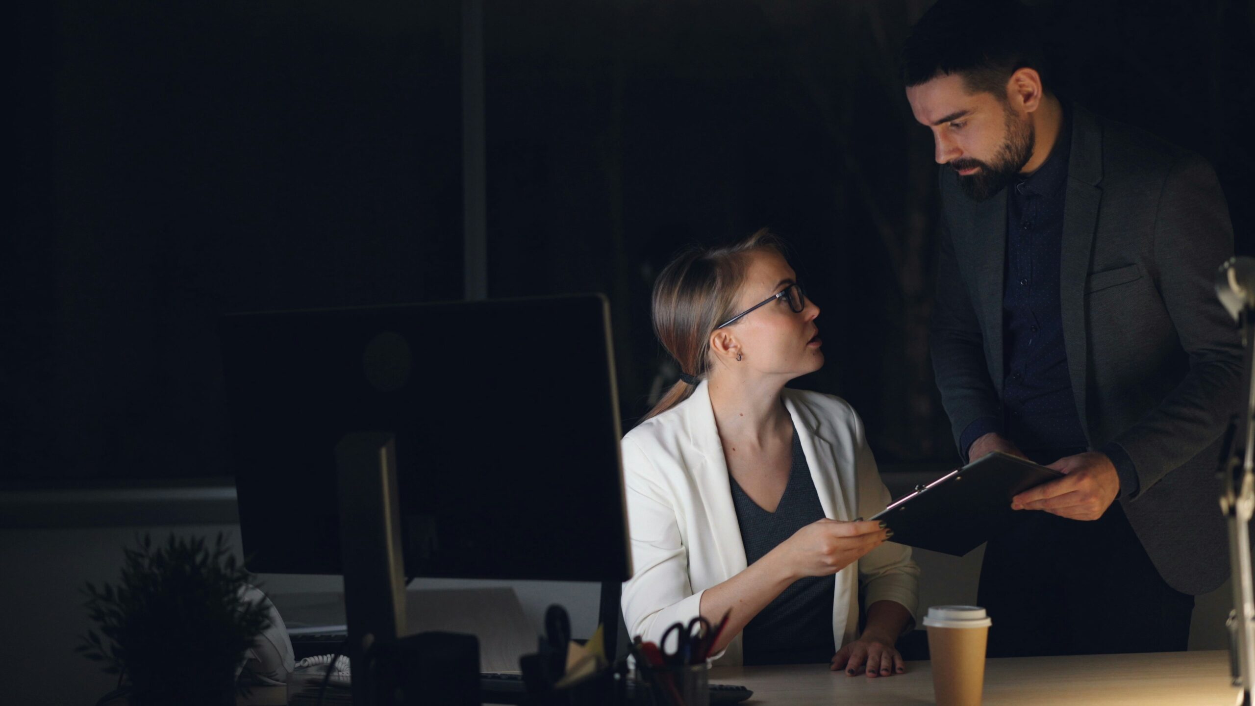 legal staffing agency — attorney and paralegal reviewing urgent caseload documents together during a late night surge at a law firm