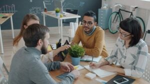 new graduates placed by a staffing agency collaborating with their new team in a modern professional office