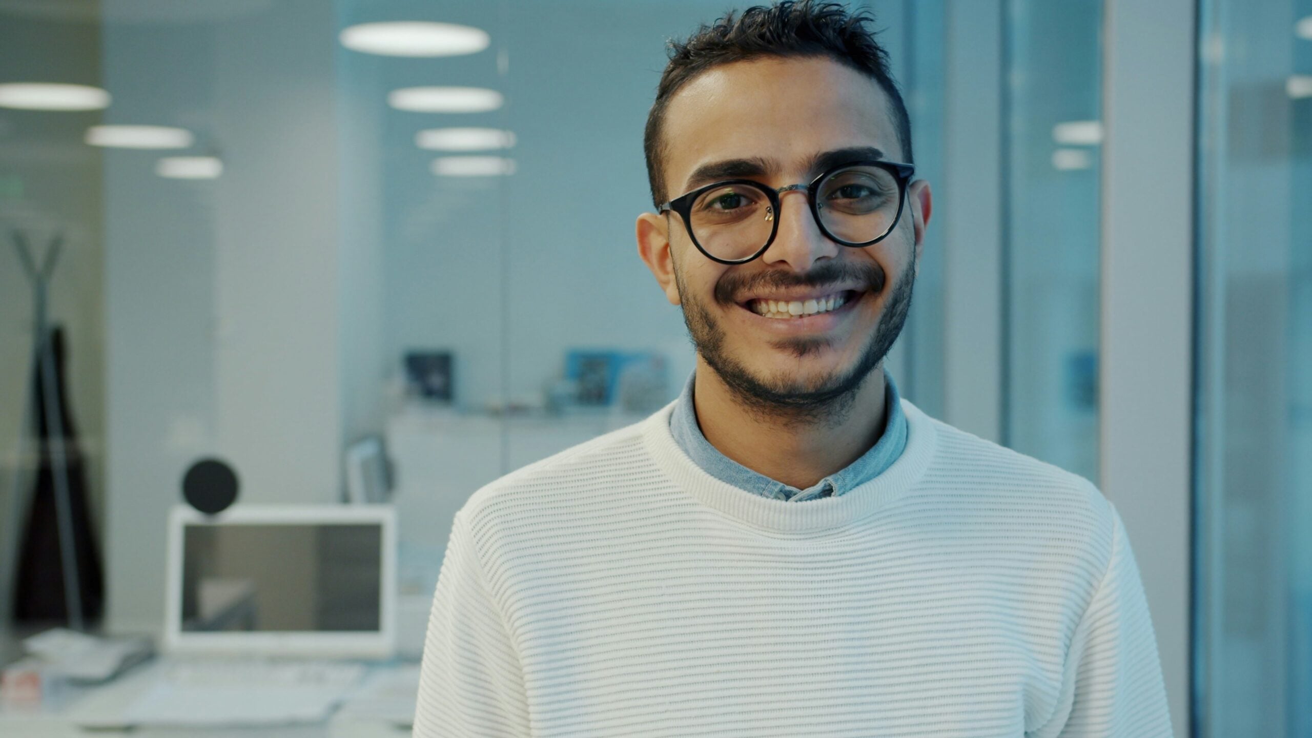 staffing agency for new graduates — confident young professional smiling on his first day at a new job secured through a staffing agency
