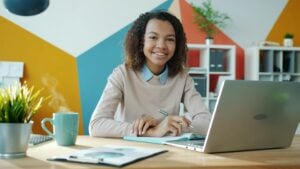 temp to hire jobs DC — young professional smiling at desk after successfully starting a new role in Washington DC