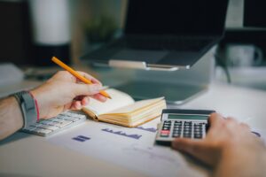 accounting jobs through a staffing agency — accounting professional working with a calculator and financial documents at a professional desk