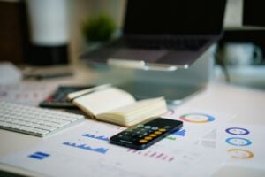 new graduate planning 401k contributions at their first job — financial charts and calculator on a professional desk representing retirement savings decisions
