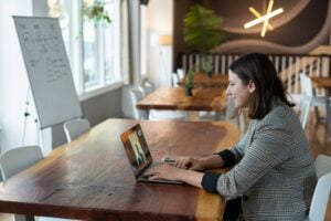 interview tips for new graduates — young professional on a video interview preparing for their first professional interview on a laptop in a modern workspace.
