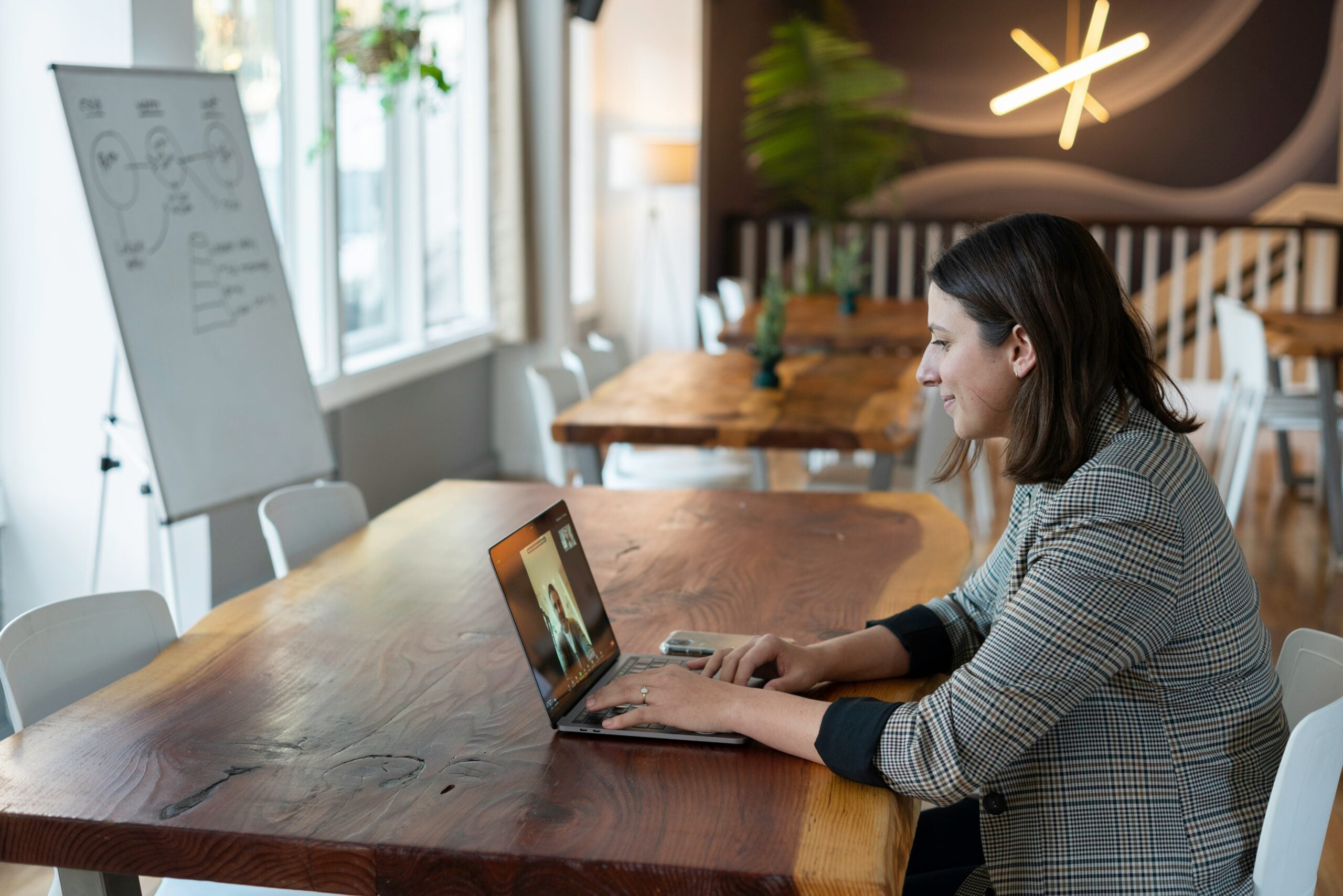 interview tips for new graduates — young professional on a video interview preparing for their first professional interview on a laptop in a modern workspace.