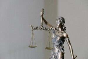 law firm staffing agency — Lady Justice statue representing legal professional staffing decisions between paralegals and legal assistants