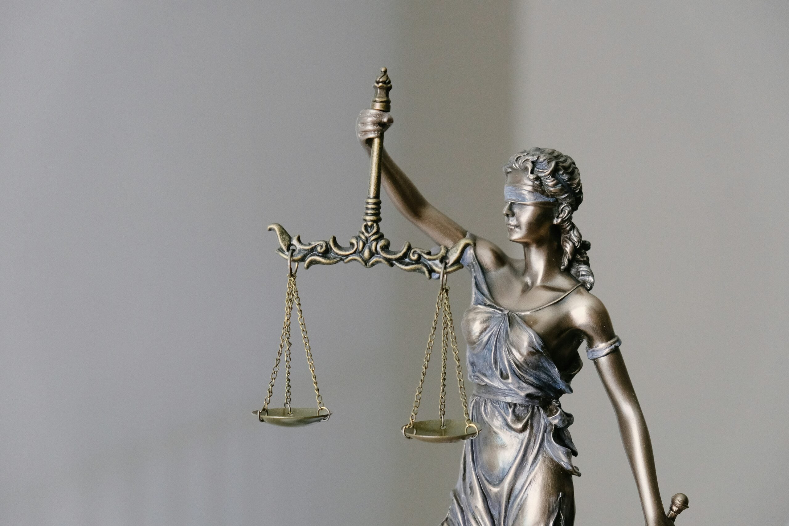law firm staffing agency — Lady Justice statue representing legal professional staffing decisions between paralegals and legal assistants