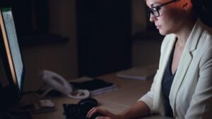 legal assistant interview — professional woman preparing for a law firm interview by researching the firm on a computer at her desk