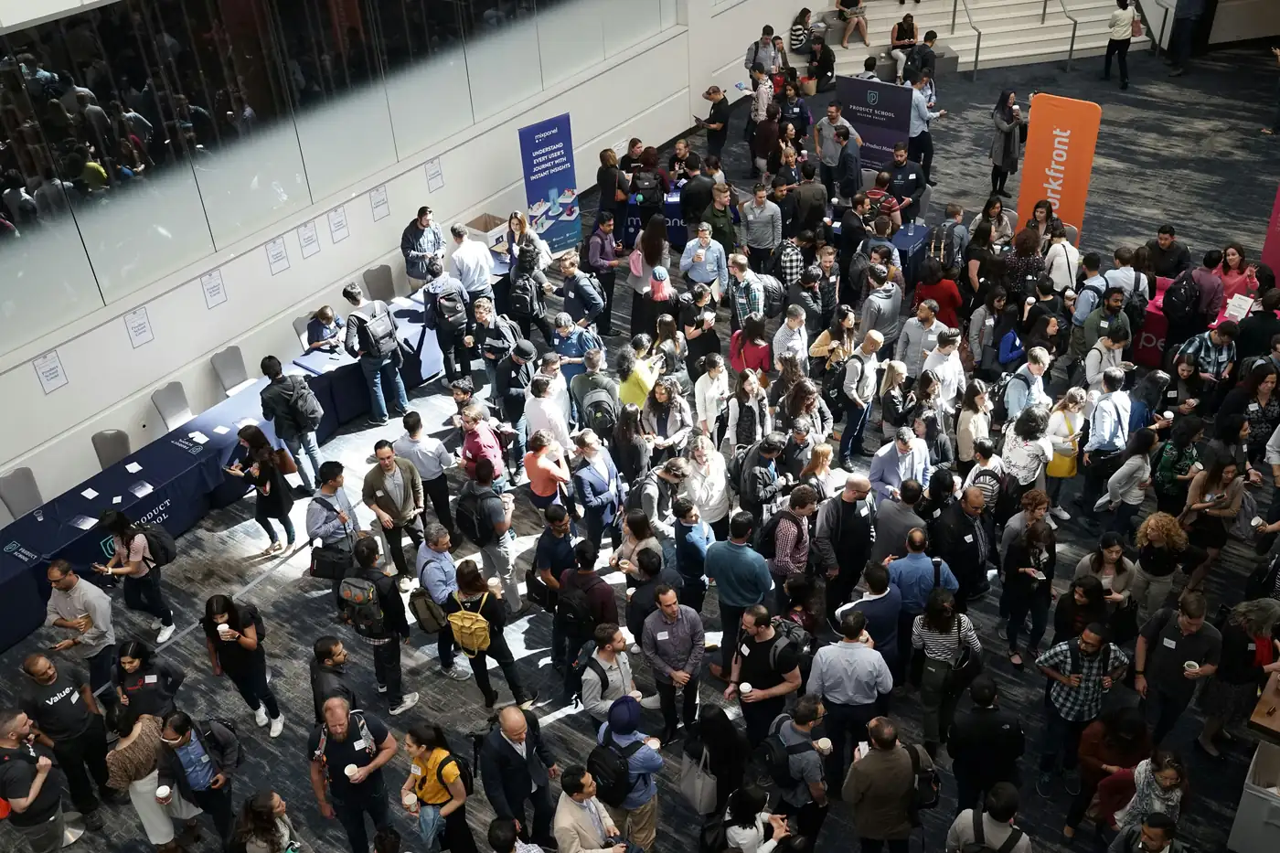A busy conference floor with registration tables and exhibitor booths that rely on temporary event staff.