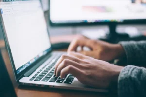 A job seeker using AI to write their resume on a laptop.